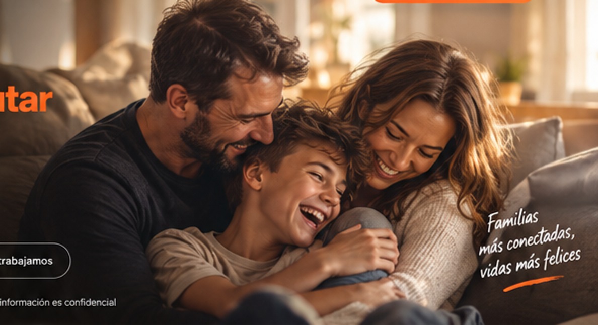 Padre y madre abrazando y riendo con su hijo adolescente en el sofá